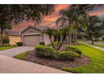 Charming single-story home featuring a well-manicured lawn and tropical landscaping at 247 Bell Tower Xing W, Poinciana, FL 34759