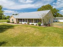 Charming single-story home with a well-manicured lawn, screened front porch, and a durable metal roof at 3048 Cherokee Rd, St Cloud, FL 34772