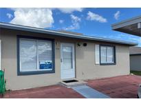 Charming single-story home featuring stucco siding, blue trim, and a well-manicured brick pathway at 344 Winter Ridge Blvd # 344, Winter Haven, FL 33881