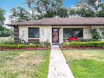 Charming home with a landscaped yard, flower beds, and beautiful walkway at 12539 Orangewood Ct, Tavares, FL 32778