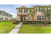 Inviting two-story townhome with well-maintained lawn and charming front facade at 1818 Katz Crossing Dr, Kissimmee, FL 34744