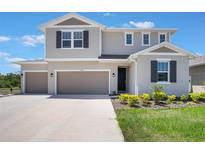Beautiful two-story home with a three car garage, manicured lawn, and a well-kept garden at 2821 Cathy Blvd, Winter Haven, FL 33880
