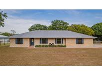 Charming brick home with a modern metal roof, complemented by blue shutters and a well-manicured front lawn at 4091 Lippman Rd, St Cloud, FL 34772