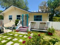 Charming home with a quaint front porch, vibrant flowers, and stepping stones leading to the entrance at 455 E Palmetto Ave, Longwood, FL 32750