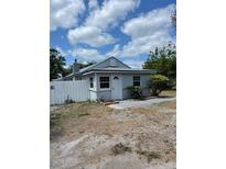 Charming single-story home with a light gray exterior, a well-kept front yard, and a white fence at 5562 Old Tampa Hwy, Davenport, FL 33896