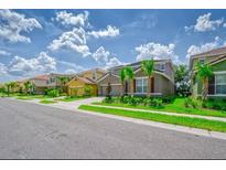 Charming street view of modern homes with well-manicured lawns and tropical landscaping on a sunny day at 6086 Broad Oak Dr, Davenport, FL 33837