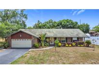 Charming single-story brick home with a two-car garage and beautifully landscaped front yard at 724 Knob Hill Cir, Kissimmee, FL 34744