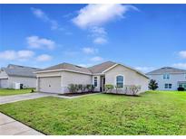 Charming single-story home with manicured lawn and beautiful landscaping at 724 Lake Cummings Blvd, Lake Alfred, FL 33850