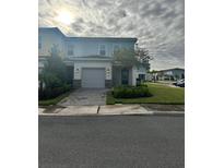 Charming two-story townhome with lush landscaping and a paved driveway at 755 Driving Range Ct, Reunion, FL 34747
