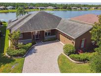 Stunning lakefront home with a brick driveway and well-maintained landscaping at 759 Glendora Rd, Poinciana, FL 34759