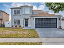 Charming two-story home with a well-maintained lawn and a two-car garage, located in a Gathering-friendly neighborhood at 1176 Epson Oaks Way, Orlando, FL 32837