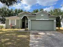 Charming single-story home featuring a two-car garage and nicely landscaped front yard at 15408 Groose Point Ln, Clermont, FL 34714