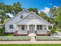 Charming home featuring a white picket fence, covered porch, and a beautifully landscaped front yard at 217 W Bay St, Winter Garden, FL 34787