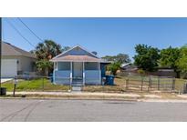 Charming single-story home featuring a cozy front porch, fenced yard, and classic architectural details at 31 Cedar St, Haines City, FL 33844
