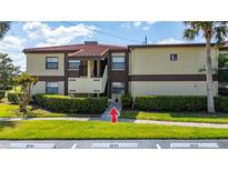 Condo building with well-maintained landscaping, tile roof, and neatly trimmed bushes at 3235 Candle Ridge Dr # 102, Orlando, FL 32822