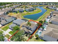 Beautiful aerial view of the property, backing onto a serene pond with neighboring homes and lush landscaping at 4739 Cumbrian Lakes Dr, Kissimmee, FL 34746