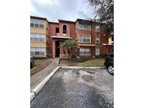Cozy condominium with a terracotta facade, well-kept landscaping, and assigned parking at 5160 Conroy Rd # 26, Orlando, FL 32811