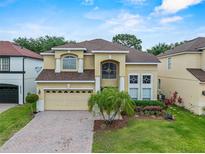 Inviting two-story home with a brick driveway, manicured lawn, and a two-car garage at 5321 Los Palma Vista Dr, Orlando, FL 32837