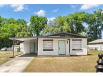 Charming single-story home with a carport, light blue doors, and fresh exterior paint under a sunny sky at 620 Plum Ln, Altamonte Springs, FL 32701