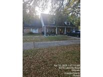 Charming home with a well-kept lawn and mature trees providing ample shade at 6419 Lakeville Rd, Orlando, FL 32818