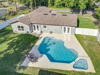 Aerial view of a home highlighting a backyard pool, patio furniture, and a fenced-in yard at 7823 Bell Blvd, Orlando, FL 32810