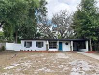 Charming single-story home featuring a blue front door and a covered carport at 906 San Domingo Rd, Orlando, FL 32808