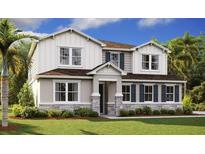 Charming two-story home with stone accents, white siding, blue shutters, and a beautifully landscaped front yard at 1058 Cloud Ridge Ct, Mount Dora, FL 32757