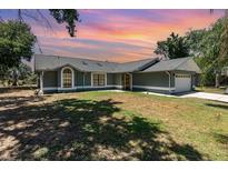 Charming single-story home featuring arched windows, a two-car garage, and a well-maintained lawn at 1100 Anne Elisa Cir, St Cloud, FL 34772