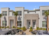 Charming townhome featuring a stone facade, tidy landscaping, and a welcoming entrance at 1385 Peaceful Nature Way, Clermont, FL 34714
