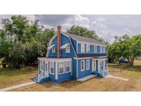 Charming two-story home featuring a blue exterior, a brick chimney, and a well-manicured front lawn at 1400 Florida Ave, St Cloud, FL 34769