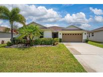Charming single-story home with a lush, green lawn, mature landscaping, and a two-car garage at 1532 Angler Ave, Kissimmee, FL 34746
