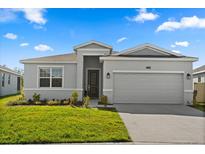 Charming single-story home featuring a well-manicured lawn and a two-car garage at 2156 Merrybells Dr, Kissimmee, FL 34746