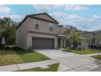 Charming two-story home with a two-car garage and well-maintained lawn and fresh landscaping at 2189 Teneroc Trl, Lakeland, FL 33801