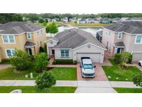 Charming single-Gathering home features manicured lawn and a brick driveway, set against a serene pond backdrop at 3298 Stratton Cir, Kissimmee, FL 34744