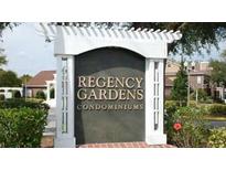 Community sign for Regency Gardens Condominiums with lush landscaping and mature trees at 4301 Lizshire Ln # 306, Orlando, FL 32822