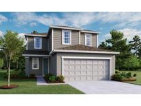 Charming two-story home features a symmetrical facade, neutral color palette, and attached two-car garage at 725 Lake Dell Rd, Dundee, FL 33838