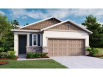 Charming single-story home featuring stone accents, a two-car garage, and lush green landscaping at 730 Lake Dell Rd, Dundee, FL 33838