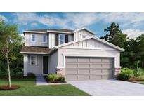 Two story home with a two car garage, neutral color palette, stone accents, and manicured lawn at 737 Lake Dell Rd, Dundee, FL 33838