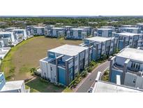 An aerial view of modern townhouse-style condos with manicured landscaping and a well-kept lawn at 7740 Sandy Ridge Dr # 236, Reunion, FL 34747