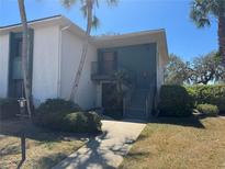 Inviting two-story condo with palm trees, lush landscaping, and a charming walkway leading to the entrance at 8 Buck Cir # 8, Haines City, FL 33844