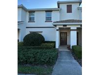 Inviting townhome with a well-maintained lawn and neatly trimmed shrubs at 9079 Dogleg Dr, Davenport, FL 33896