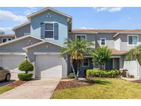 Charming townhome with a well-maintained lawn, beautiful landscaping, and an attached one-car garage at 1002 Chalcedony St, Kissimmee, FL 34744