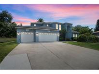 Elegant two-story home featuring a three-car garage and a long driveway at 13044 Lakeshore Grove Dr, Winter Garden, FL 34787