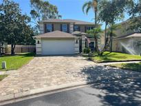 Charming two-story home featuring a paved driveway, a well-manicured lawn, and an attached two-car garage at 14963 Yorkshire Run Dr, Orlando, FL 32828