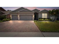 Charming single-story home featuring a brick driveway, a well-manicured lawn and a two-car garage at 1557 Alligator St, St Cloud, FL 34771