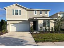 Charming two-story home featuring a two-car garage and beautifully landscaped front yard on a sunny day at 3920 Southern Vista Loop, St Cloud, FL 34772