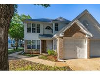 Charming two-story home featuring a brick-accented facade and attached garage, surrounded by lush landscaping at 4700 Buggywhip Ln # 102, Orlando, FL 32812