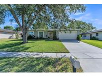Charming single-story home featuring a well-manicured lawn and a two-car garage, set under a large tree at 503 Gumwood Ct, Altamonte Springs, FL 32714