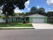 Charming green ranch-style home with a well-manicured lawn and a two-car garage at 5178 Mustang Way, Orlando, FL 32810