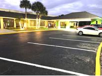 Inviting building with illuminated windows, covered entrance, and a well-lit parking area showcasing a modern facade at 5245 W Irlo Bronson Memorial Hwy # 194, Kissimmee, FL 34746